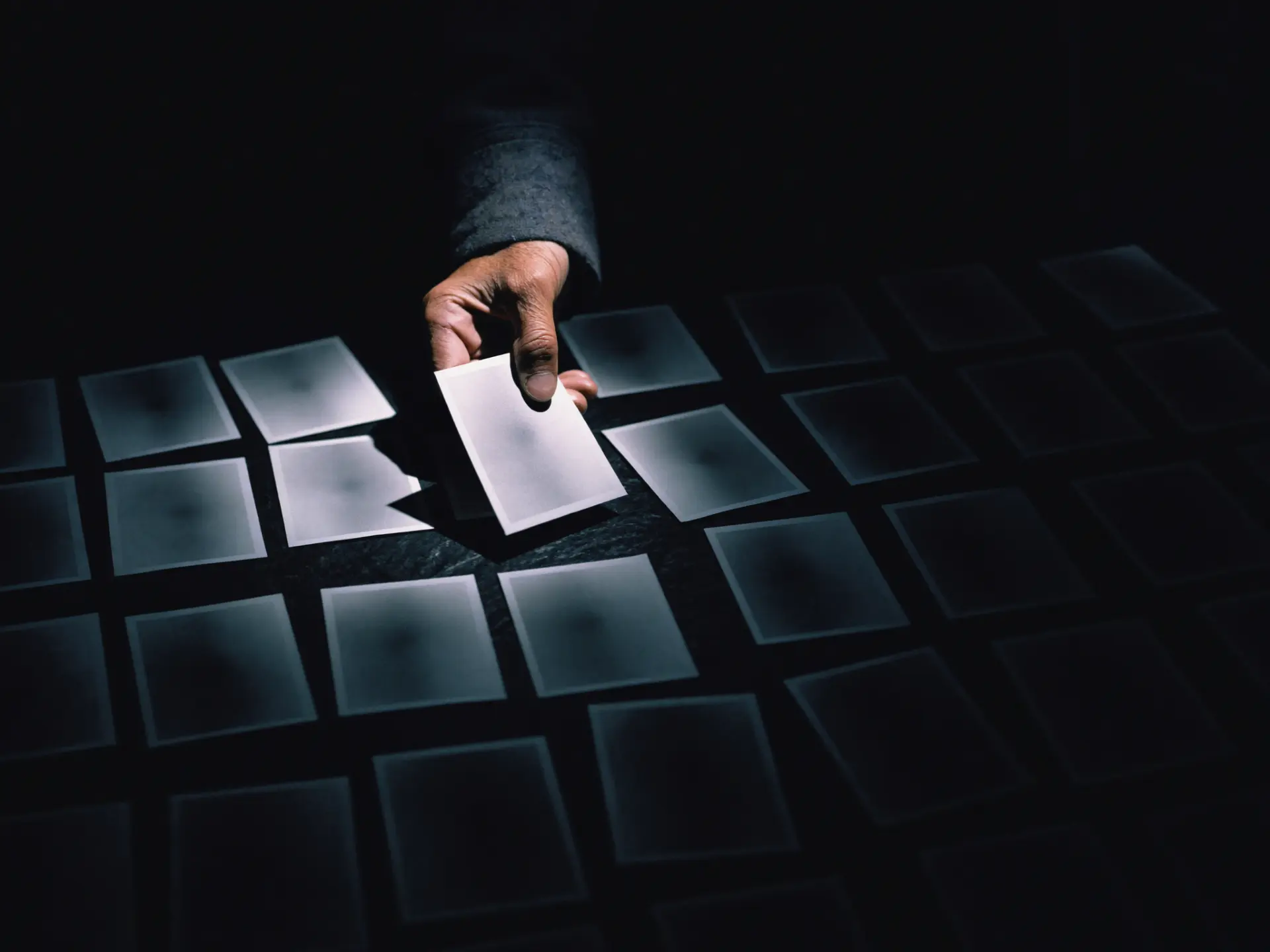 A grid of identical prints with one pulled out of line, catching the light